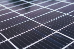 Close-up view of a solar panel with dark, grid-like photovoltaic cells used to capture and convert sunlight into electricity.