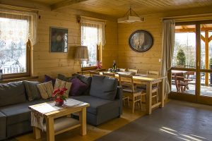 Small indoor living space with a dining table set inside a log cabin accommodation.