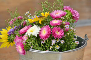 Garden flowers bouquet arrangement in a water bucket.